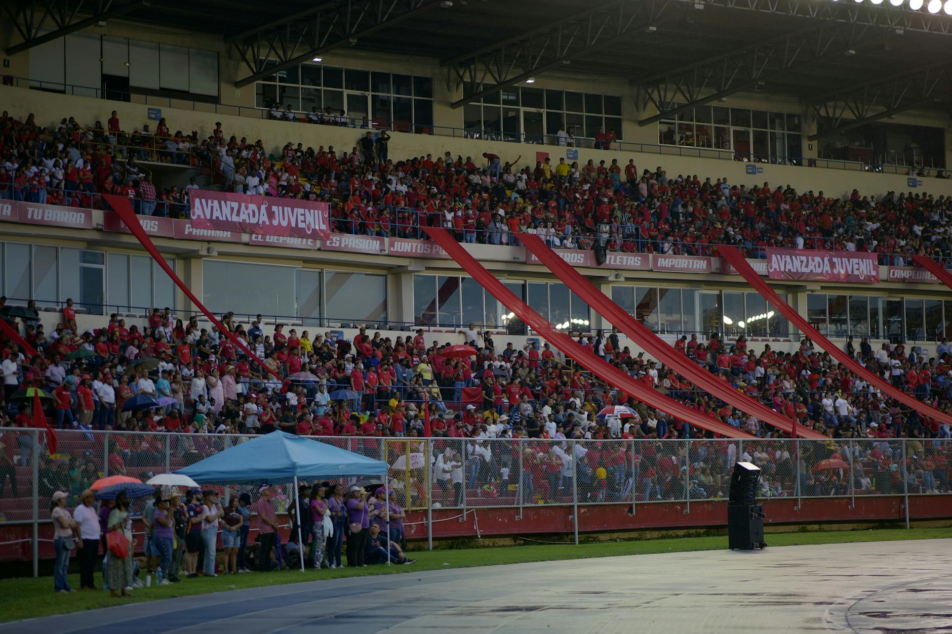 Rozemocjonowany tłum kibiców na kolorowych trybunach stadionu