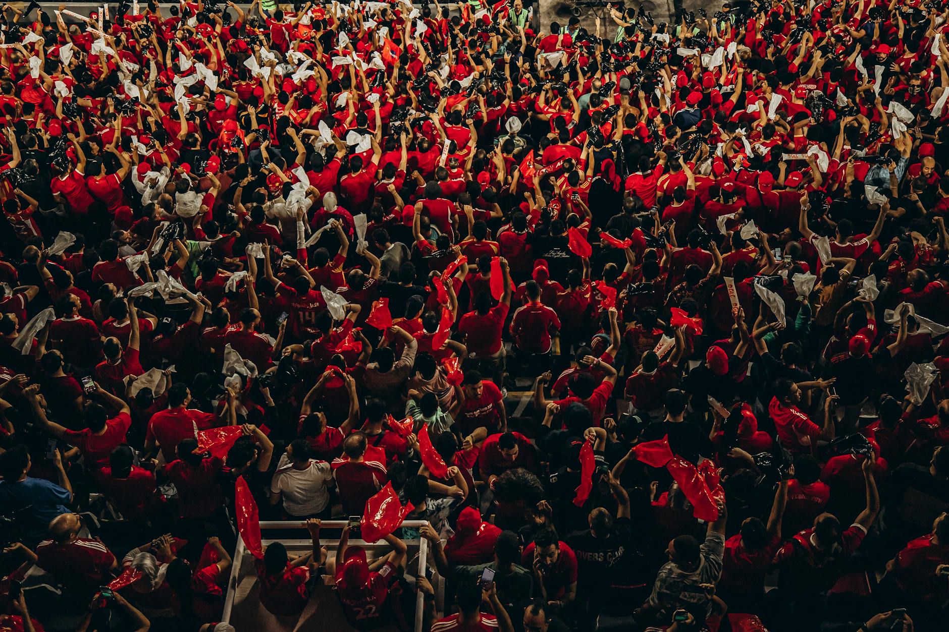 Tłum kibiców piłkarskich głośno dopinguje drużynę na stadionie
