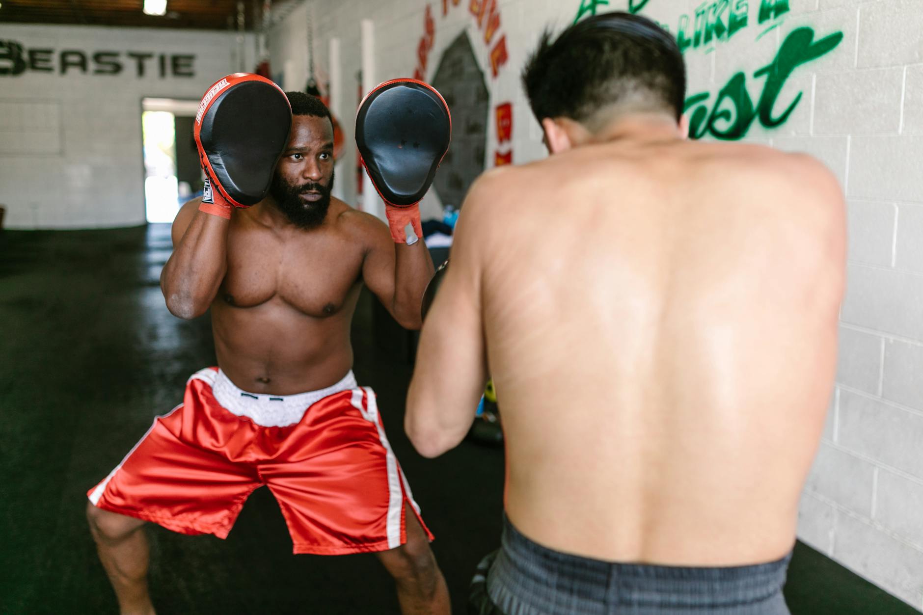 Dwóch bokserów trenuje w ringu na sali gimnastycznej
