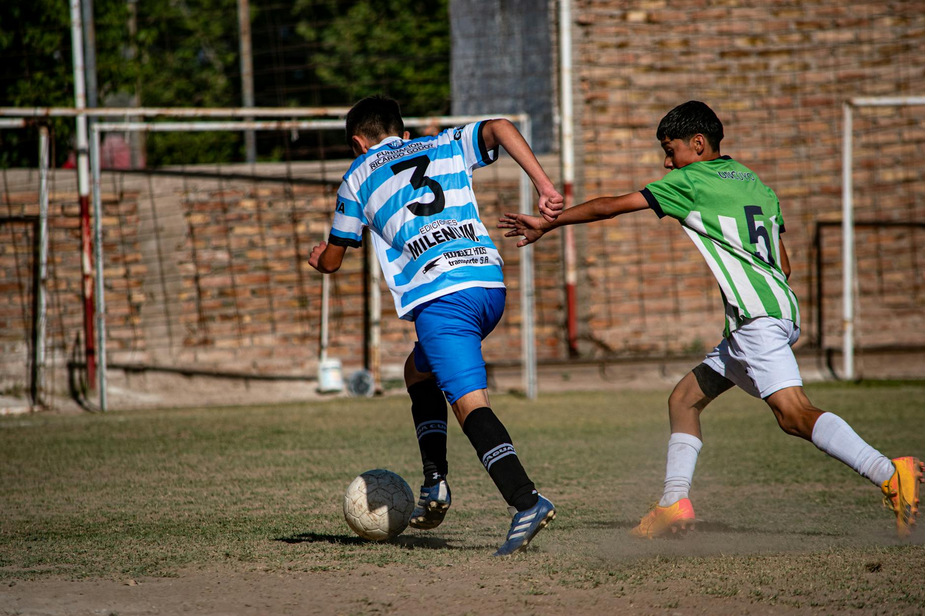 Dwóch młodych piłkarzy rywalizuje o piłkę podczas meczu