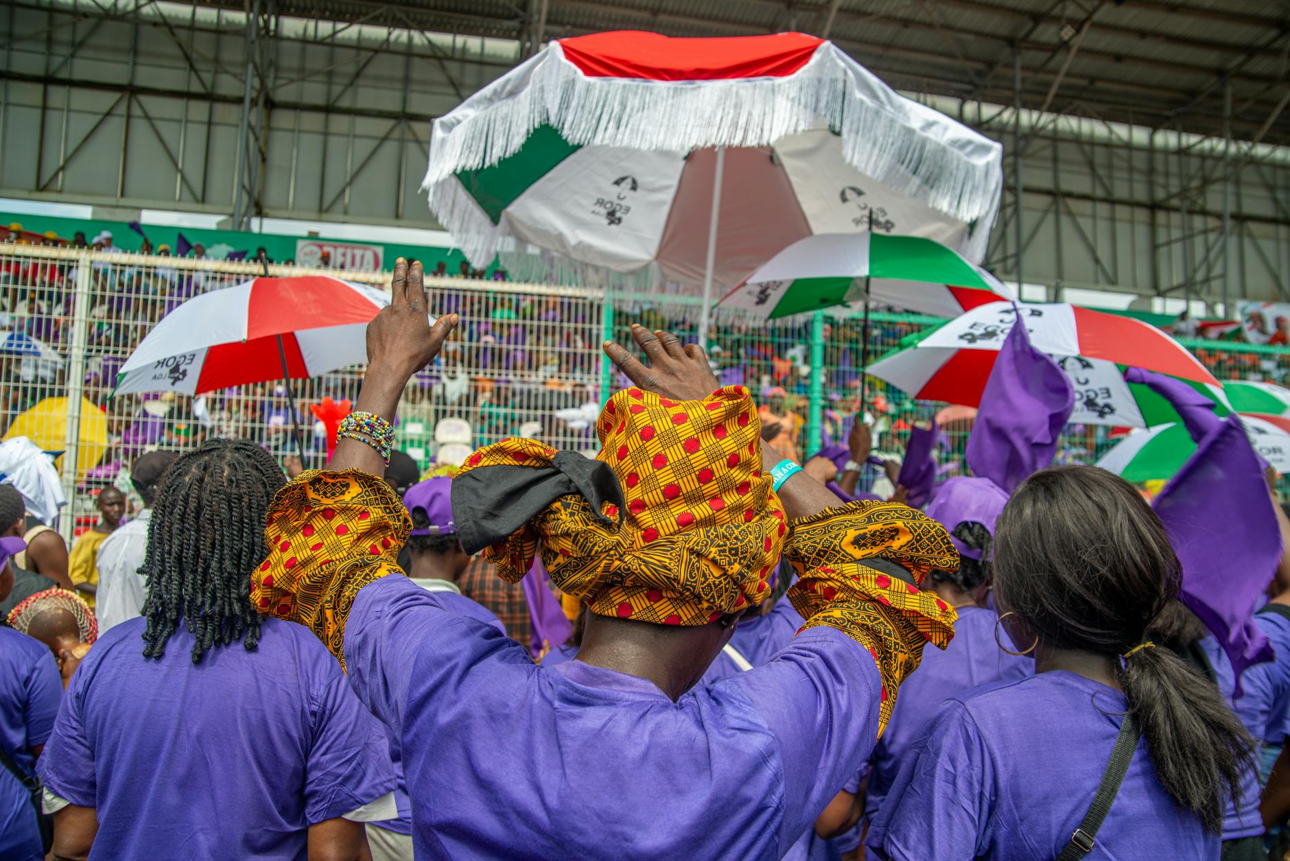 Tłum kibiców z kolorowymi parasolami na otwartym stadionie