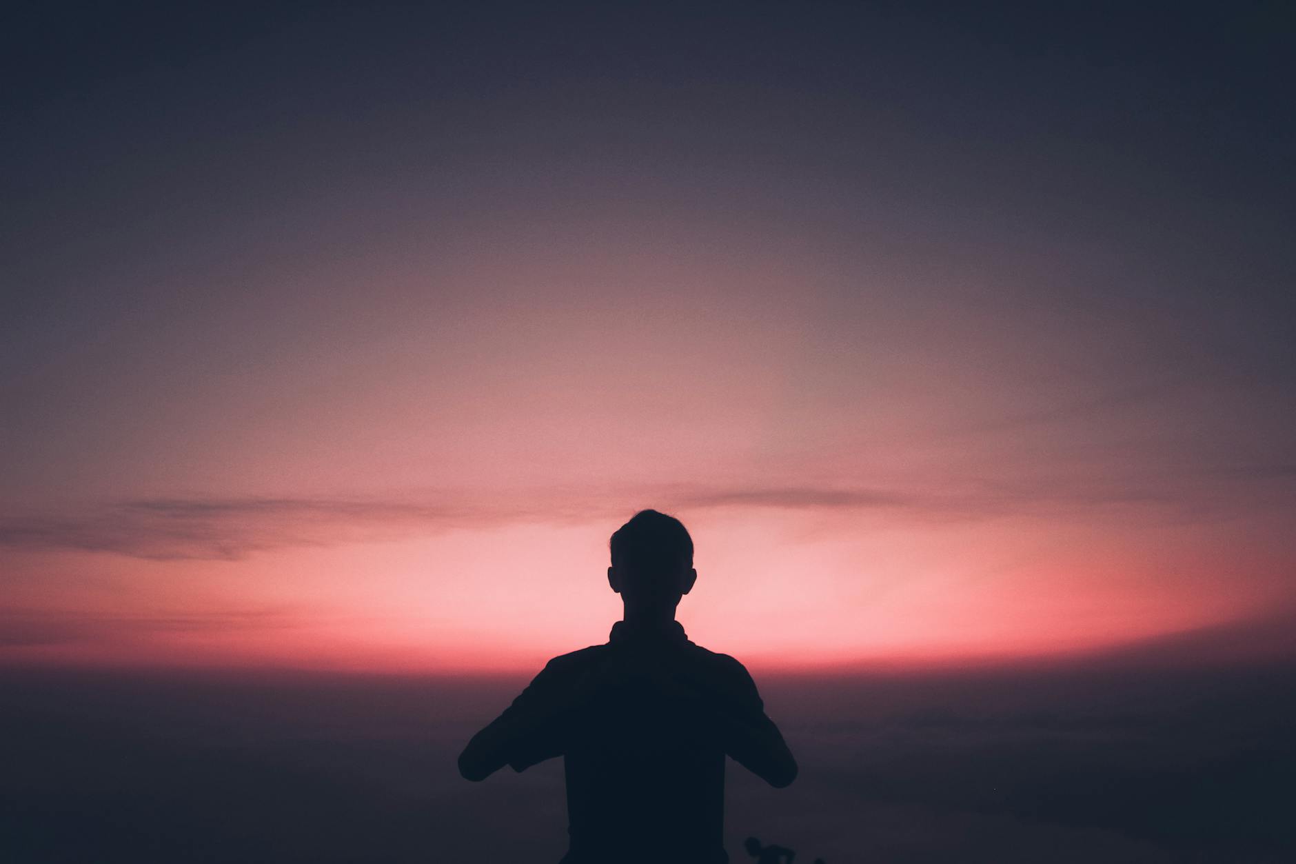 Sylwetka człowieka na tle barwnego wschodu słońca w East Java