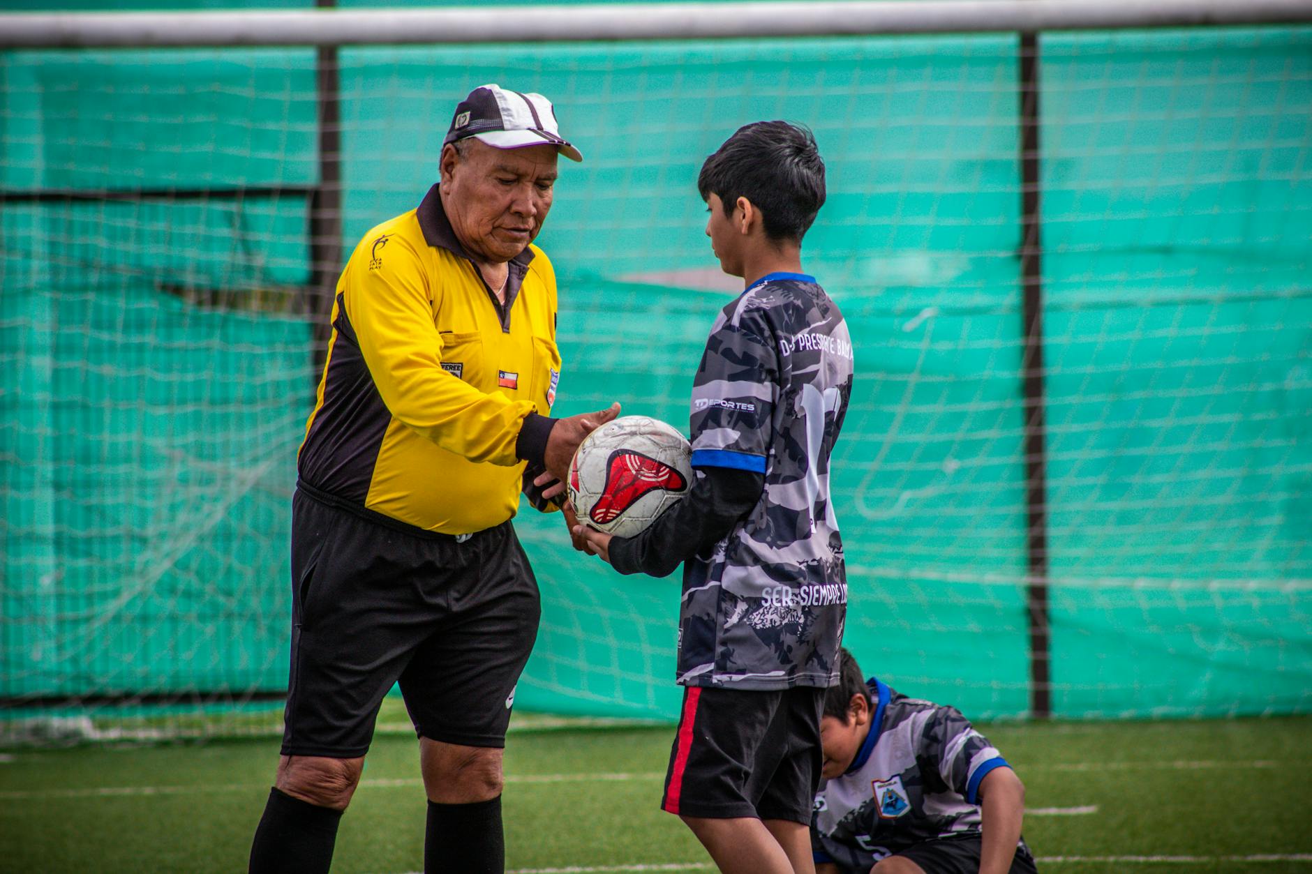 Trener instruuje młodych piłkarzy podczas treningu na boisku