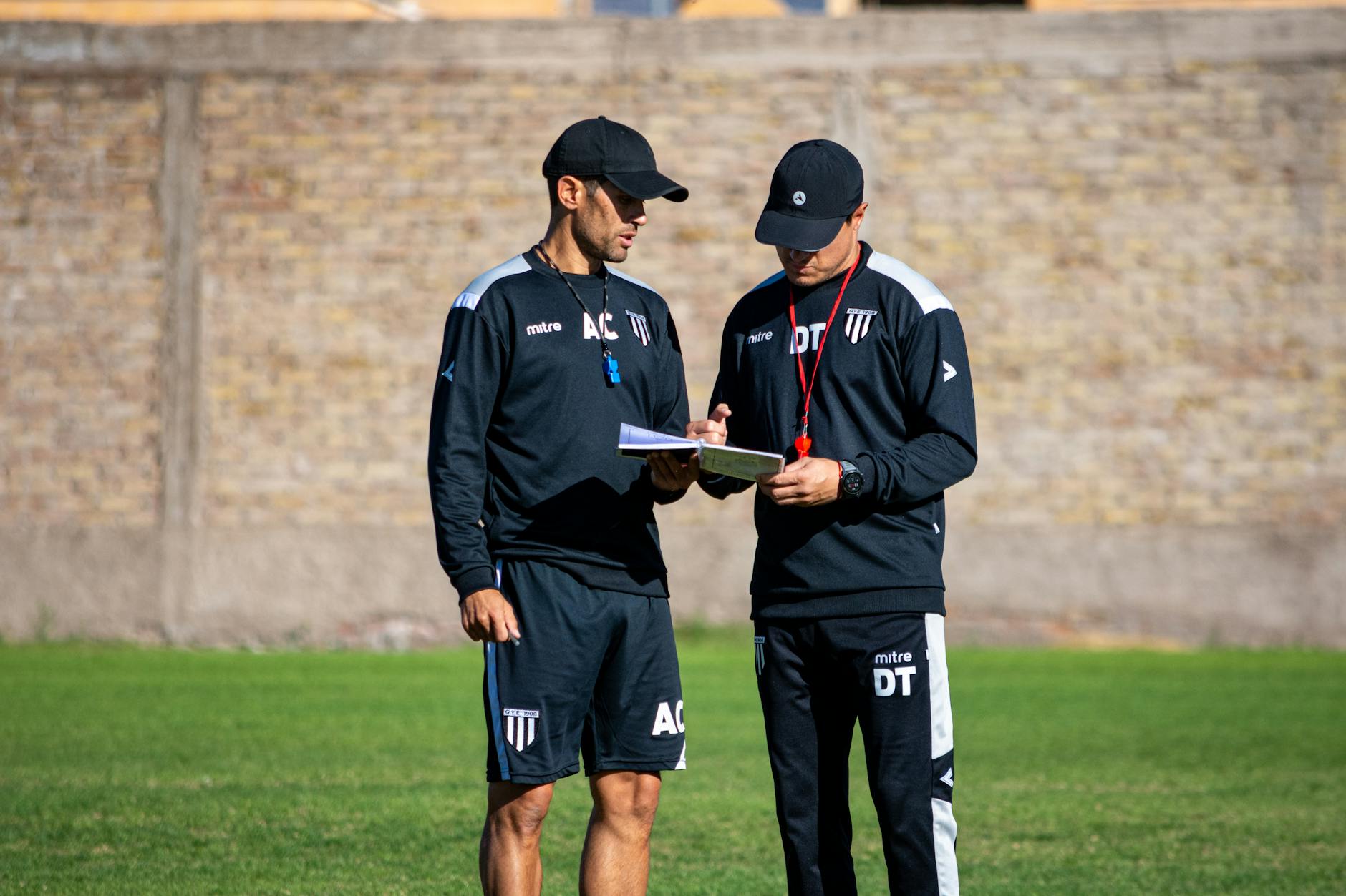 Dwaj trenerzy piłkarscy omawiają taktykę na boisku