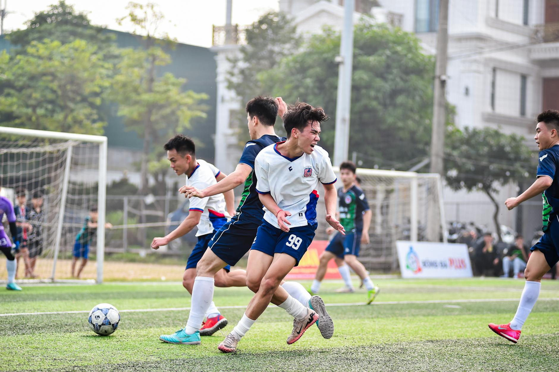 Piłkarze w akcji podczas meczu na słonecznym boisku w Hanoi