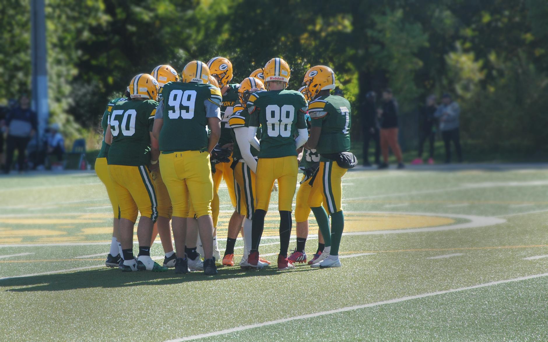 Piłkarze w strojach meczowych zbierają się w kręgu przed rozpoczęciem gry