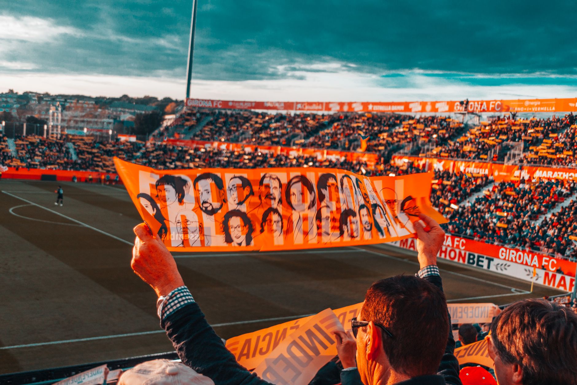 Kibice Girona FC machają kolorowym transparentem na pełnych trybunach