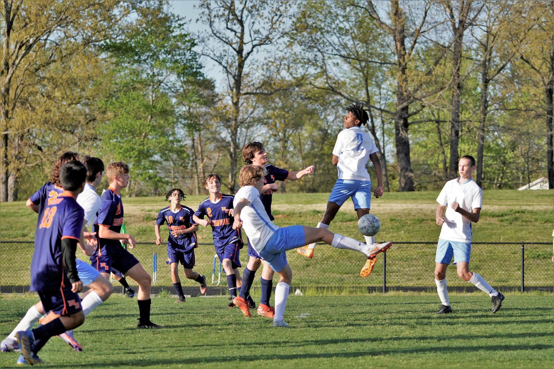 Wysoki pressing w EA FC: ustawienia taktyki i sygnały, kiedy odpuścić i wrócić do bloku Młodzi piłkarze w dynamicznej akcji podczas meczu na boisku na zewnątrz