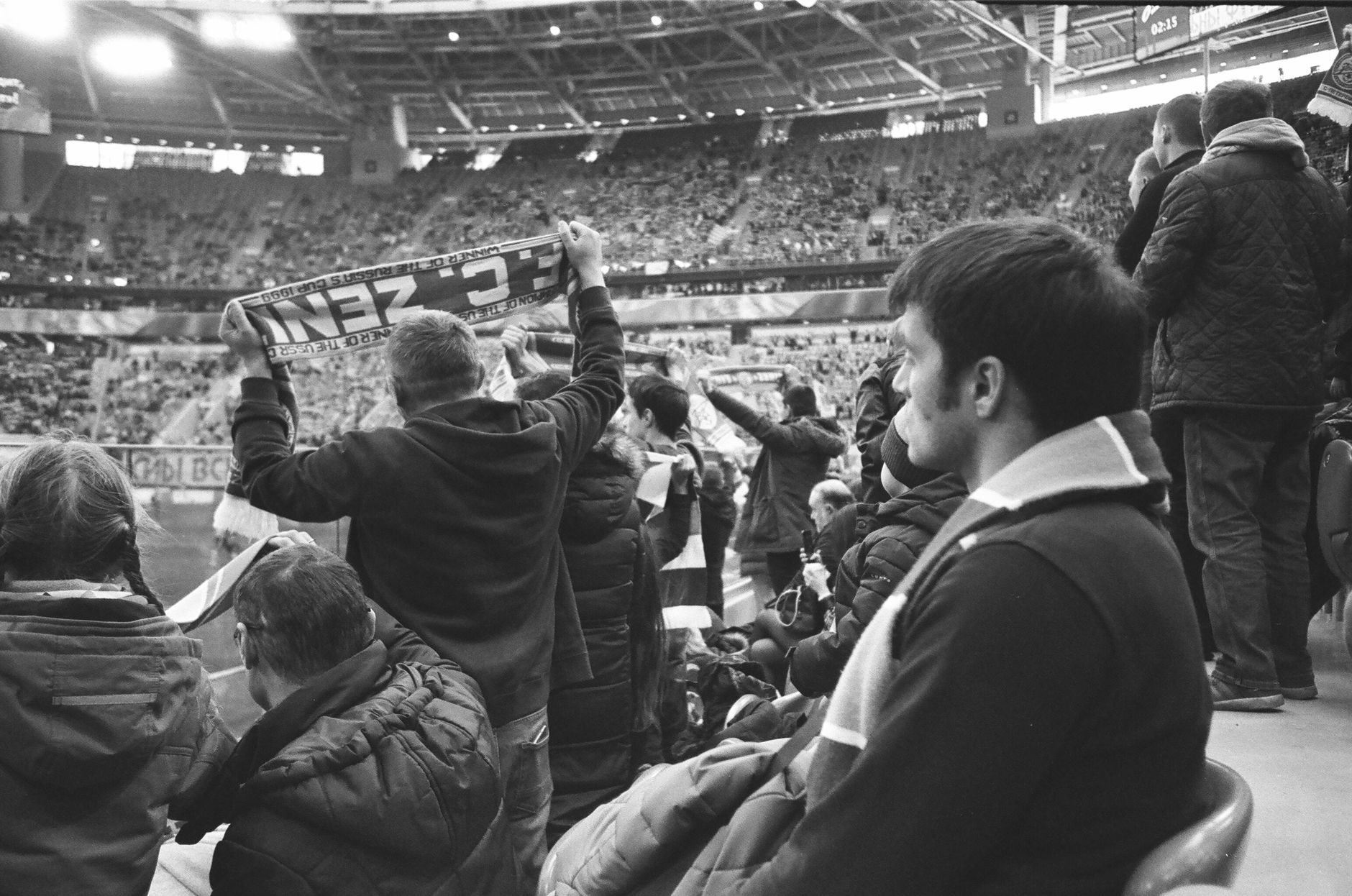 Co zabrać na wyjazd na mecz: lista rzeczy, które ratują skórę w trasie i na stadionie Kibice w ciepłych kurtkach stojący na stadionie i oglądający mecz